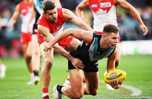 Dan Houston of Port Adelaide tackled by Jake Lloyd of the Swans during the round 15 AFL match between the Port Adelaide Power and the Sydney Swans at...
