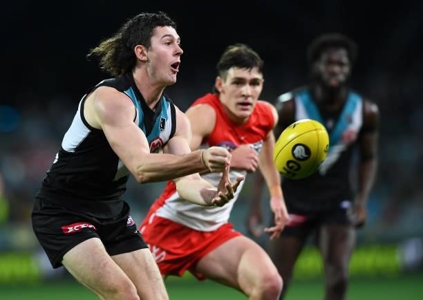 Darcy Byrne-Jones of Port Adelaide handballs during the round 15 AFL match between the Port Adelaide Power and the Sydney Swans at Adelaide Oval on...