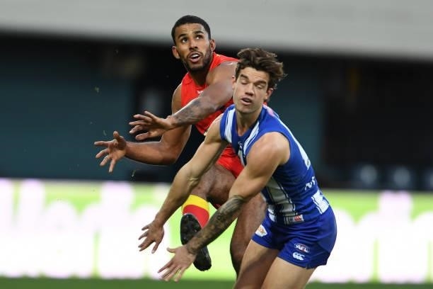 Jy Simpkin of the Kangaroos tries to smother the kick of Touk Miller during the round 15 AFL match between the North Melbourne Kangaroos and the Gold...