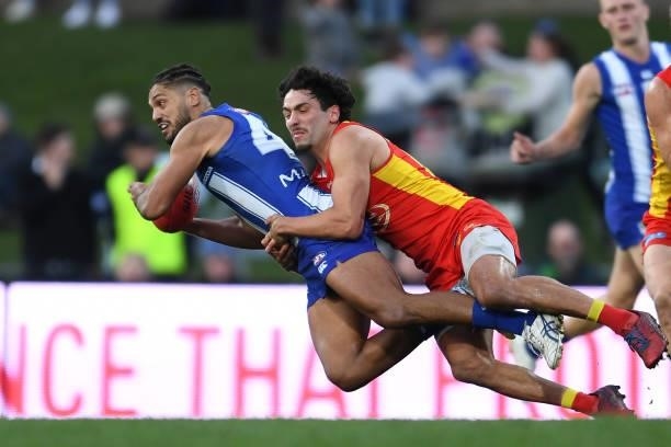 Aaron Hall of the Kangaroos is tackled by Izak Rankine of the Suns during the round 15 AFL match between the North Melbourne Kangaroos and the Gold...