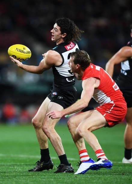 Darcy Byrne-Jones of Port Adelaide handballs over Harry Cunningham of the Swans during the round 15 AFL match between the Port Adelaide Power and the...