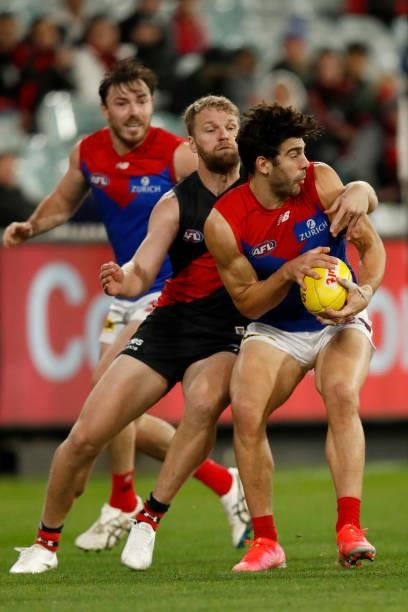 Jake Stringer of the Bombers tackles Christian Petracca of the Demons during the round 15 AFL match between the Essendon Bombers and the Melbourne...
