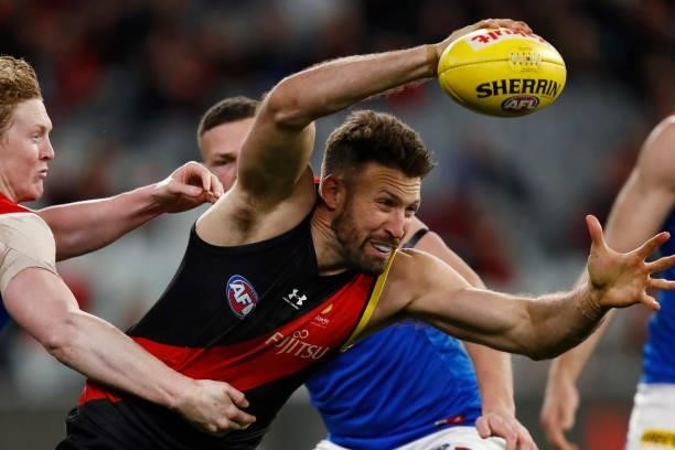 Cale Hooker of the Bombers gathers the ball during the round 15 AFL match between the Essendon Bombers and the Melbourne Demons at Melbourne Cricket...