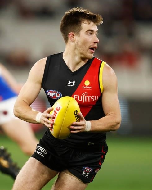 Zach Merrett of the Bombers runs with the ball during the round 15 AFL match between the Essendon Bombers and the Melbourne Demons at Melbourne...