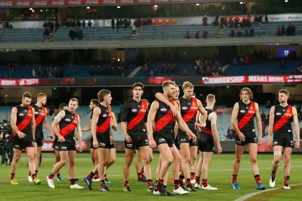 Dejected Essendon players walk from the ground after the round 15 AFL match between the Essendon Bombers and the Melbourne Demons at Melbourne...