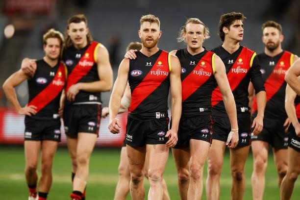 Dyson Heppell of the Bombers leads the Bombers off the field with Mason Redman of the Bombers after the round 15 AFL match between the Essendon...