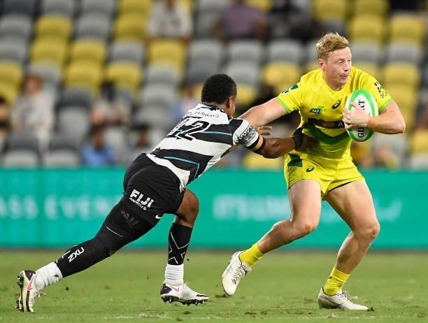 Lachlan Miller of Australia is tackled by Napolioni Bolaca of Fiji during the Oceania Sevens Challenge match between Fiji and Australia at Queensland...