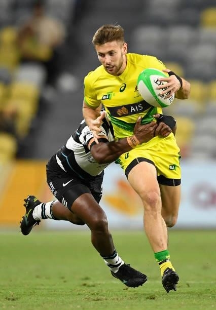 Josh Turner of Australia is tackled by Waisea Nacuqu of Fiji during the Oceania Sevens Challenge match between Fiji and Australia at Queensland...