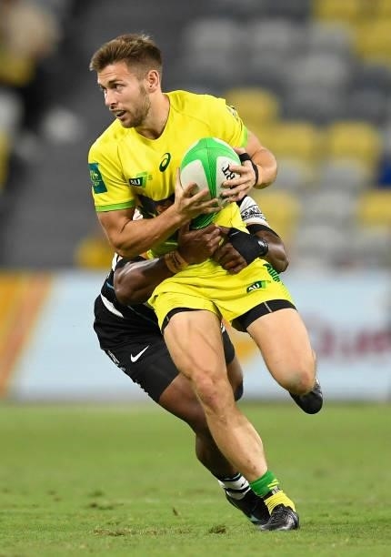 Josh Turner of Australia is tackled by Waisea Nacuqu of Fiji during the Oceania Sevens Challenge match between Fiji and Australia at Queensland...