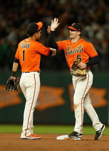 Mauricio Dubon and Mike Yastrzemski of the San Francisco Giants celebrate after a win against the Oakland Athletics at Oracle Park on June 25, 2021...
