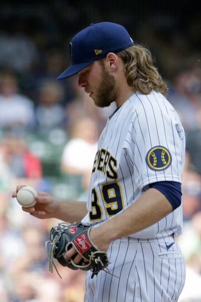 Corbin Burnes of the Milwaukee Brewers checks the baseball during the game against the Colorado Rockies at American Family Field on June 25, 2021 in...