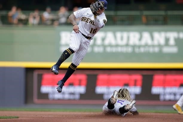 Kolten Wong takes a high throw as Raimel Tapia of the Colorado Rockies steals second base against the Milwaukee Brewers at American Family Field on...