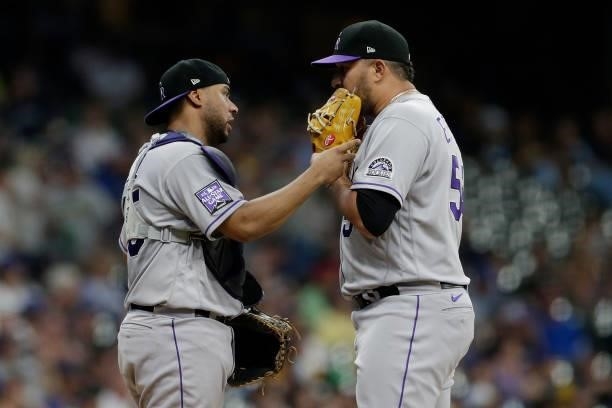 Yonathan Daza talks with Carlos Estevez of the Colorado Rockies during a mound visit against the Milwaukee Brewers at American Family Field on June...