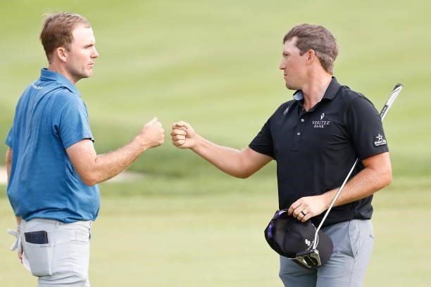 Russell Henley of the United States and Kramer Hickok of the United States fist bump on the 18th green after their third round of the Travelers...