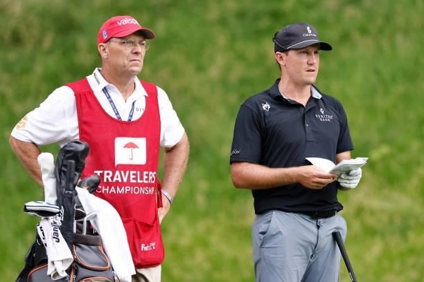 Kramer Hickok of the United States talks with his caddie on the 15th hole during the third round of the Travelers Championship at TPC River Highlands...