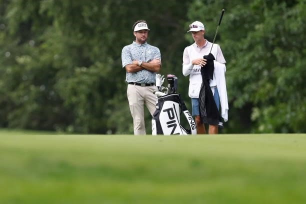 Bubba Watson of the United States talks with his caddie Ted Scott on the 14th hole during the third round of the Travelers Championship at TPC River...
