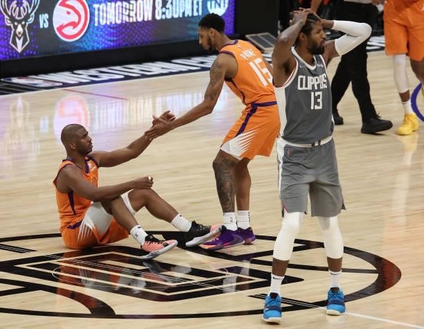 Chris Paul of the Phoenix Suns is helped up by teammate Cameron Payne after being fouled by Paul George of the LA Clippers during the second half in...