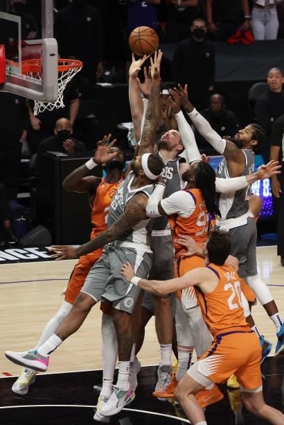 Ivica Zubac of the LA Clippers and Jae Crowder of the Phoenix Suns go up for a rebound with teammates during the second half in game four of the...
