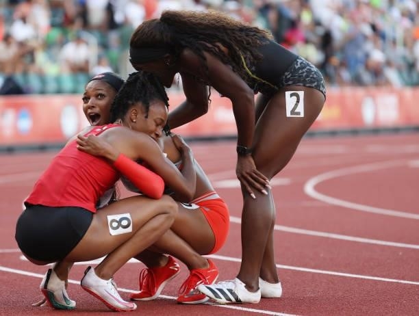 Gabby Thomas celebrates with Anavia Battle and Morolake Akinosun after crossing the finish line to win the Women's 200 Meters Final on day nine of...