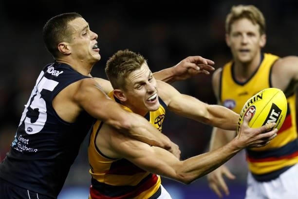 Ed Curnow of the Blues tackles David Mackay of the Crows high during the round 15 AFL match between the Carlton Blues and the Adelaide Crows at...