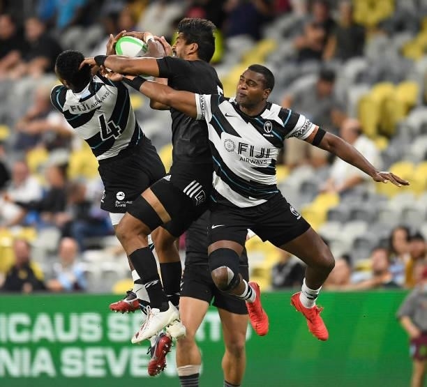 Dylan Collier of New Zealand contests the ball with Iosefo Masi and Josua Vakurunabili of Fiji during the Oceania Sevens Challenge match between New...