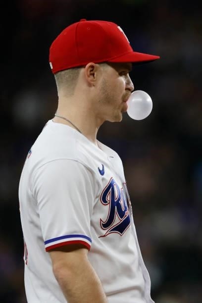 Brock Holt of the Texas Rangers blows a bubble between pitches while playing against the Kansas City Royals at Globe Life Field on June 26, 2021 in...