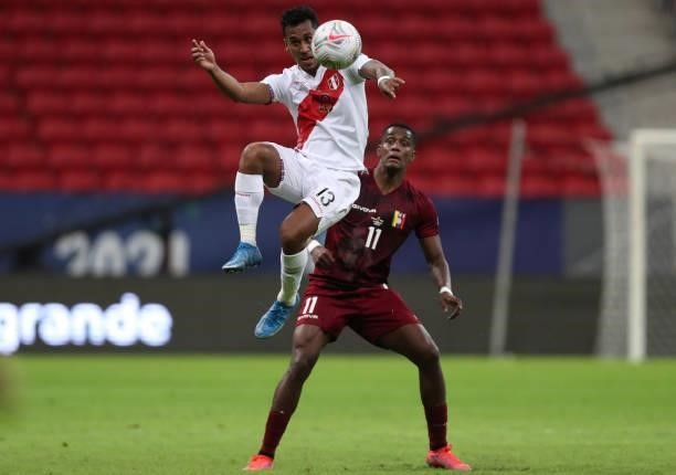 Renato Tapia of Peru heads the ball as Sergio Cordova of Venezuela looks on during a Group B Match between Venezuela and Peru as part of Copa America...