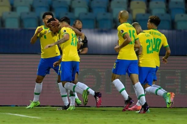 Eder Militao of Brazil celebrates with teammates after scoring the first goal of his team during a group B match between Brazil and Ecuador as part...