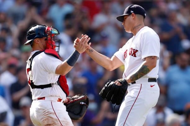 Yacksel Rios of the Boston Red Sox celebrates with Christian Vazquez after defeating the New York Yankees 9-2 at Fenway Park on June 27, 2021 in...