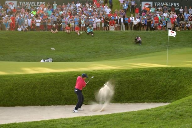 Kramer Hickok of the United States plays a shot from a bunker on the 18th hole during the fourth playoff hole of the final round of the Travelers...