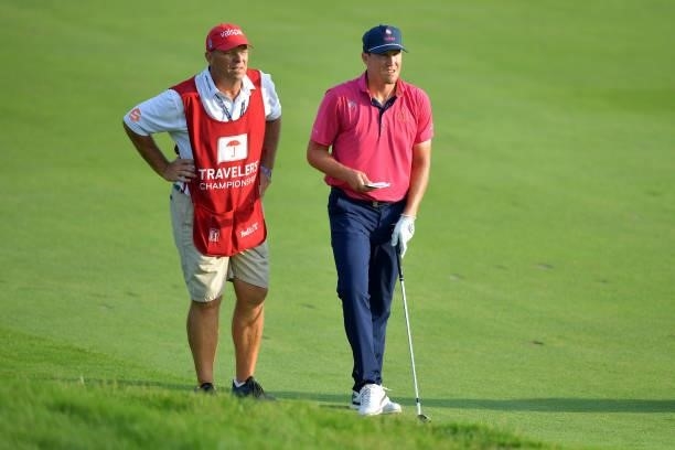Kramer Hickok of the United States talks with his caddie on the 18th hole during the fourth playoff hole of the final round of the Travelers...