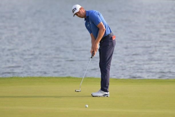 Harris English of the United States putts on the 17th green in the third playoff hole during the final round of the Travelers Championship against...