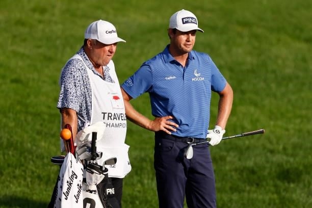 Harris English of the United States talks with his caddie on the 18th hole during the second playoff hole in the final round of the Travelers...