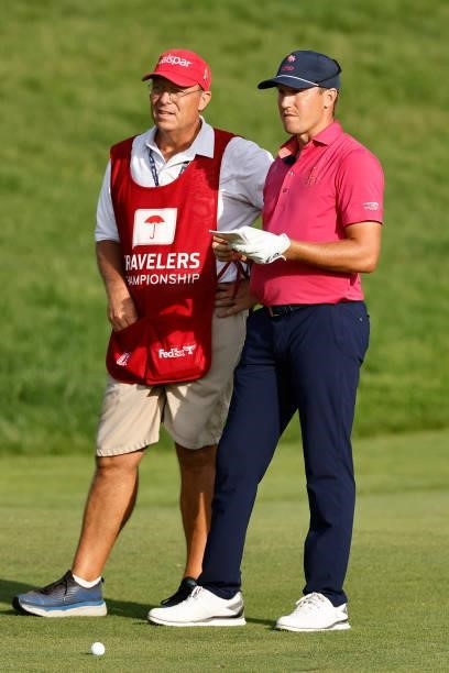 Kramer Hickok of the United States talks with his caddie on the 18th hole during the final round of the Travelers Championship at TPC River Highlands...