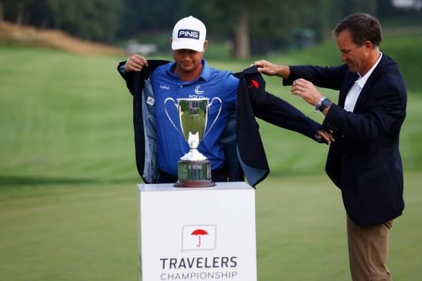 Harris English of the United States is presented with the winner's jacket after winning the Travelers Championship in the eighth playoff hole against...