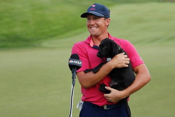 Kramer Hickok of the United States laughs with his dog, Elvis, after losing to Harris English of the United States in the eighth playoff hole in the...