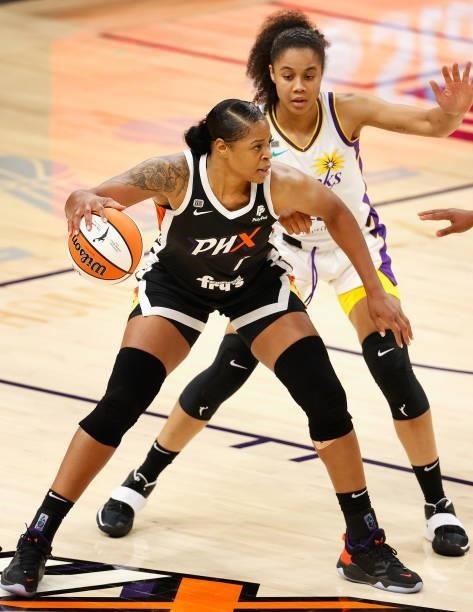 Kia Vaughn of the Phoenix Mercury handles the ball against Nia Coffey of the Los Angeles Sparks during the first half of the WNBA game at Phoenix...