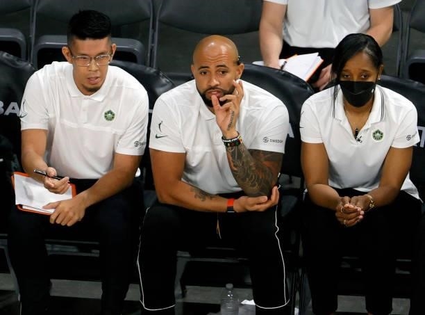 Assistant coaches Perry Huang and Ryan Webb, and head coach Noelle Quinn of the Seattle Storm talk on the bench during their game against the Las...