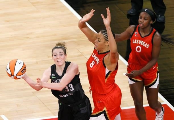 Katie Lou Samuelson of the Seattle Storm passes under pressure from Liz Cambage of the Las Vegas Aces as Jackie Young of the Aces defends during...