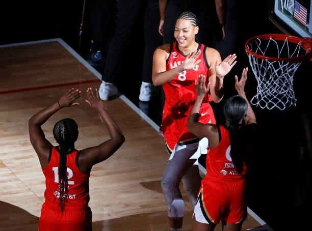 Liz Cambage of the Las Vegas Aces is greeted on the court by teammates Chelsea Gray and Jackie Young during player introductions before the team's...