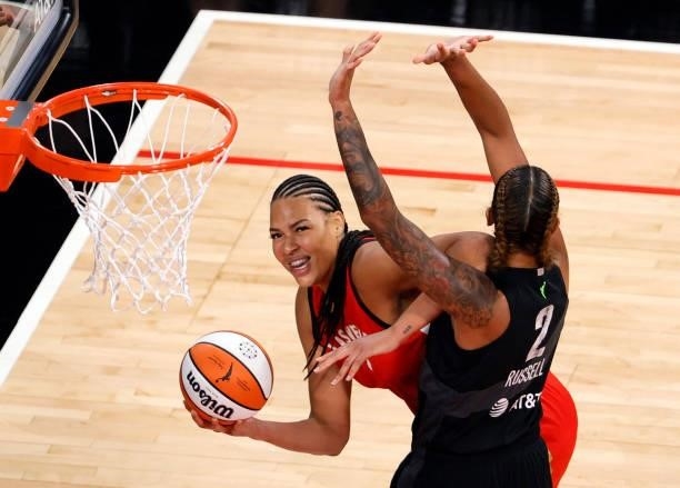 Liz Cambage of the Las Vegas Aces is called for traveling as she is guarded by Mercedes Russell of the Seattle Storm during their game at Michelob...