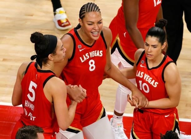 Liz Cambage of the Las Vegas Aces is picked up from the floor by Dearica Hamby, and Kelsey Plum during their game against the Seattle Storm at...