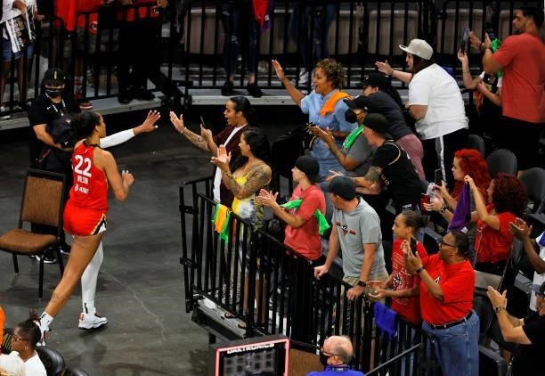 Ja Wilson of the Las Vegas Aces high-fives fans as she runs off the court after the team's 95-92 overtime victory over the Seattle Storm at Michelob...