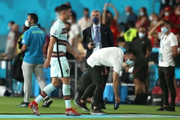 Team member picks up Cristiano Ronaldo's captain's armbands as he leaves the pitch following defeat in the UEFA Euro 2020 Championship Round of 16...