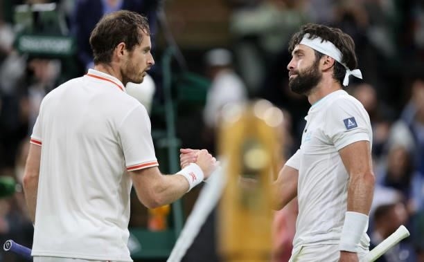 Andy Murray of Great Britain and Nikoloz Basilashvili of Georgia shake hands at the net after their Men's Singles First Round match during Day One of...