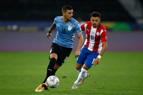 Giorgian De Arrascaeta of Uruguay competes for the ball with Angel Romero of Paraguay during a group A match between Uruguay and Paraguay as part of...