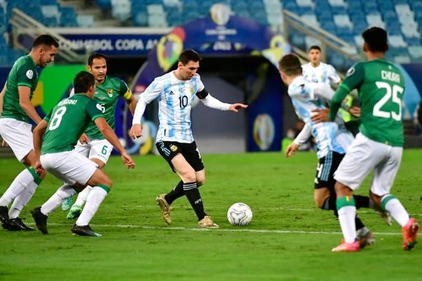 Lionel Messi of Argentina controls the ball against Leonel Justiniano of Bolivia during a Group A match between Argentina and Bolivia as part of Copa...