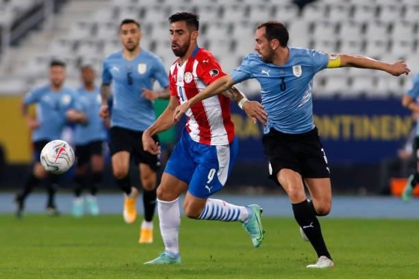 Gabriel Avalos of Paraguay competes for the ball with Diego Godin of Uruguay during a group A match between Uruguay and Paraguay as part of Conmebol...