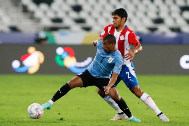 Nicolas De La Cruz of Uruguay competes for the ball with Robert Rojas of Paraguay during a group A match between Uruguay and Paraguay as part of...