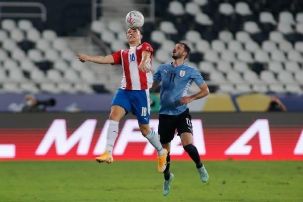 Braian Samudio of Paraguay jumps for the ball with Matias Viña of Uruguay during a group A match between Uruguay and Paraguay as part of Conmebol...